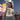 Woman eating a snack at a carnival with a Ferris wheel in the background