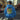 Person wearing a blue hoodie with a colorful graphic on the back, standing on a city street.