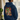 Person wearing a navy blue hoodie with a colourful graphic design of Hashie eating noodles