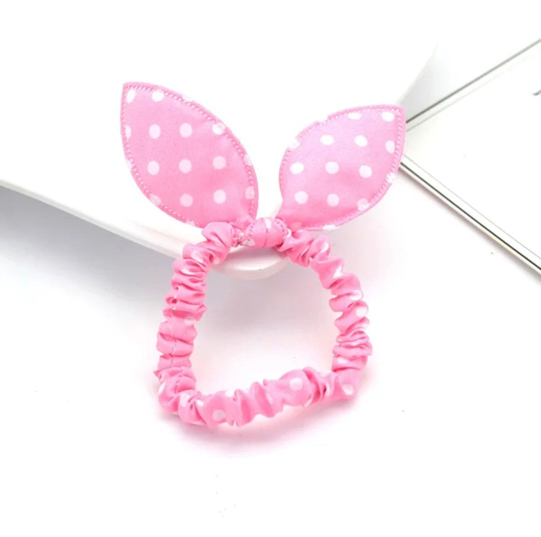 The image illustrates a soft pink bunny ear headband sprinkled with white polka dots, epitomizing cuteness and playfulness for Hashies or as a delightful adornment for desk pets.
