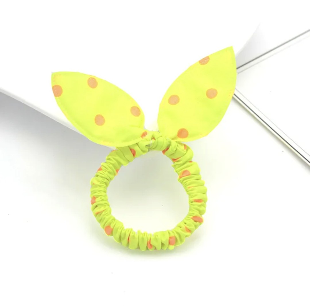 The image depicts a neon yellow bunny ear headband adorned with orange polka dots, a vibrant accessory that brings a burst of energy to Hashies or as an eye-catching piece for desk pets.