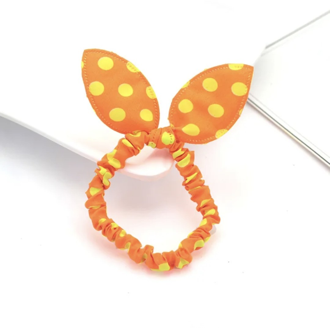 The image displays an orange bunny ear headband with cheerful yellow polka dots, an accessory that radiates warmth and fun for Hashies or as a vibrant addition to desk pets.