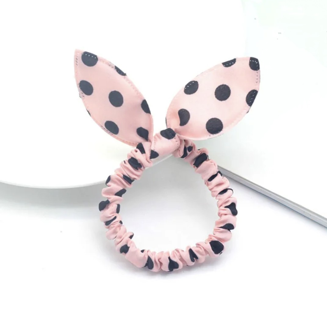The image presents a pink bunny ear headband featuring charming black polka dots, a sweet and stylish accessory for Hashies or as a cute addition for desk pets.