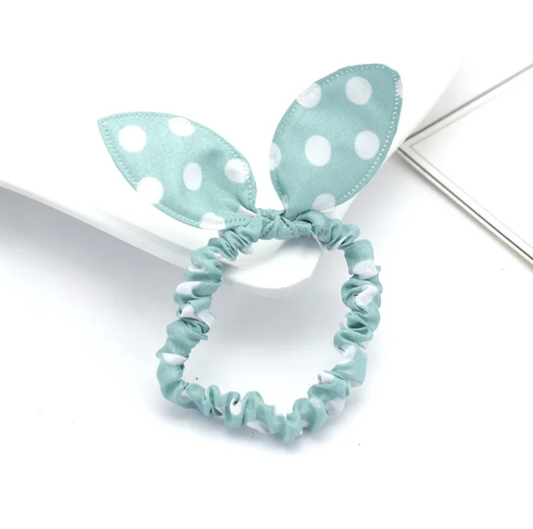 The image depicts a mint green bunny ear headband patterned with white polka dots, an accessory that brings a breath of fresh air to Hashies or as a light-hearted touch for desk pets.