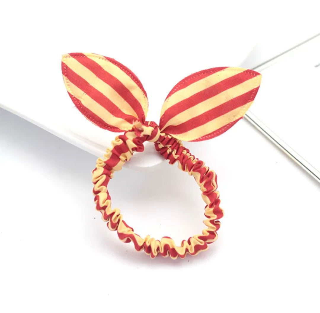 The image features a golden yellow and red striped bunny ear headband, an accessory that exudes a warm, carnival-like charm for Hashies or as an exuberant touch for desk pets.